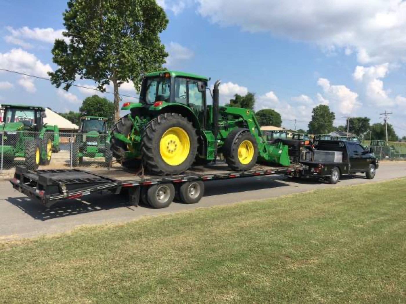 John Deere tractor loaded on a trailer for delivery by Lesmot Equipment